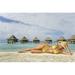 French Polynesia Tuamotu Islands Rangiroa Atoll Woman Lounging On Beach Luxury Resort Bungalows In Background. Poster Print (36 x 22)