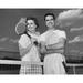 Close-up view of young couple holding tennis rackets and smiling Poster Print (24 x 36)