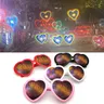 Gli occhiali con effetti a forma di cuore d'amore guardano le luci cambiano a forma di cuore di