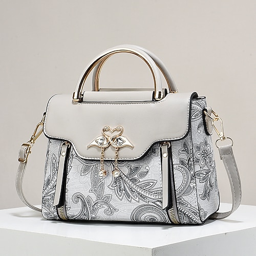 Elegante Damenhandtasche mit Schwanenanhänger – schwarz-weißes Paisley-Design mit goldenen Akzenten und verstellbarem Riemen