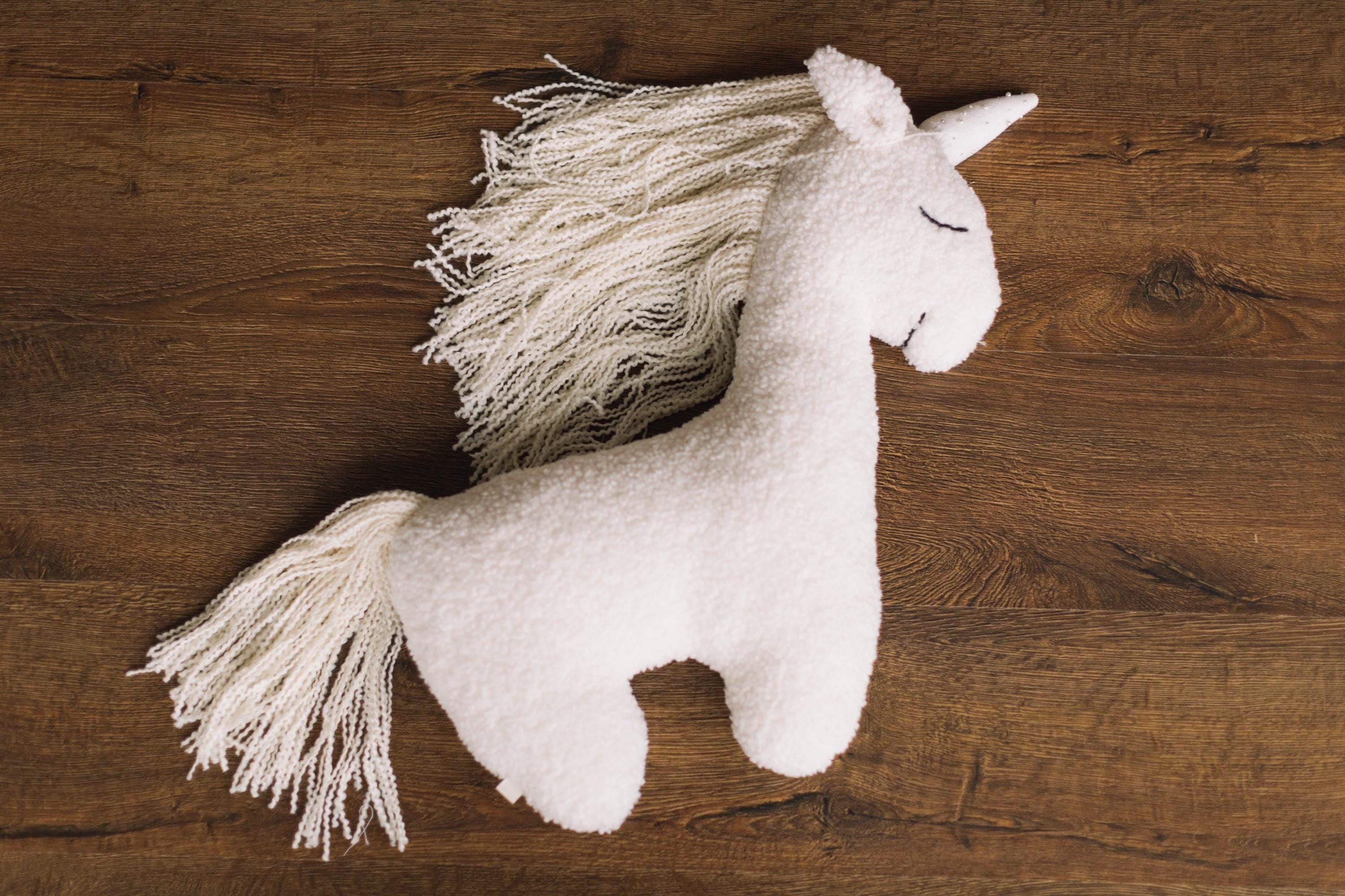 Giocattolo unicorno bianco neonato in posa, cuscino a forma di animale per pose fotografiche, cuscino a forma di animale imbottito, cuscino unicorno n
