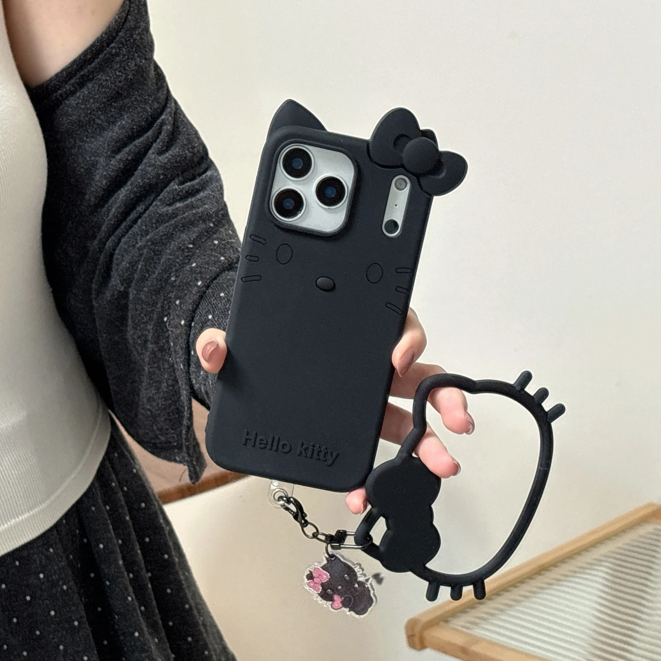 Süße und coole schwarze Hello Kitty Handyhülle für iPhone 17, 16, 15, 14, 13, 12 Pro Max Plus Cartoon Kitty Handyhülle mit Handschlaufe