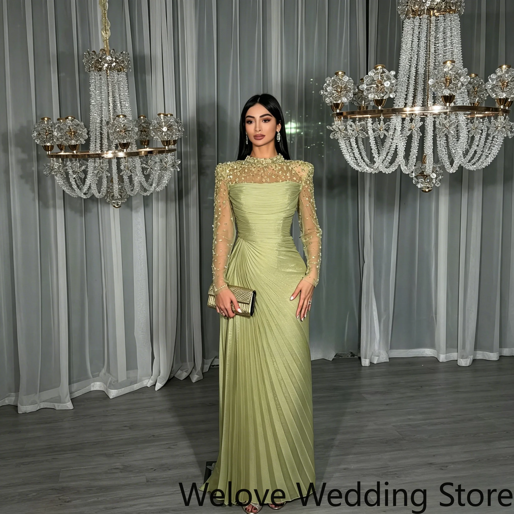 Sage‑Green Formal Evening Gown Featuring High Neckline Sheer Long Sleeves With Intricate Beaded Detail Ruched Pleated Bodice